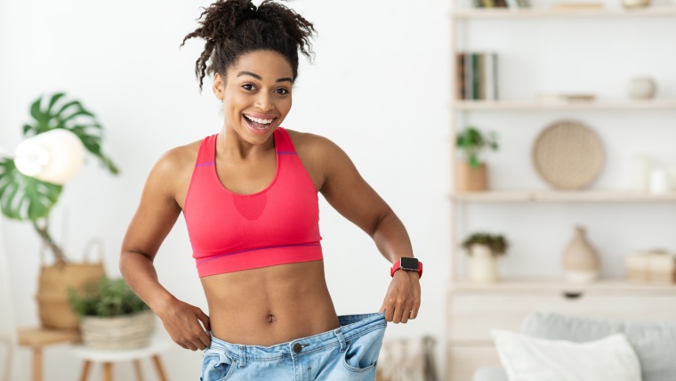 Excited Girl Wearing Too Big Jeans After Weight Loss Indoor